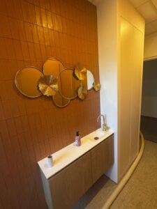 Salle de bain rénovée avec douche italienne et mur jaune
